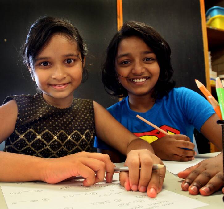 KEEPING CULTURE: 8-year-old Nethukee Jayasekera (left) with Dinara Piyasiri, 9, learning Sinhalese on the weekend.. Photo: Les Smith.