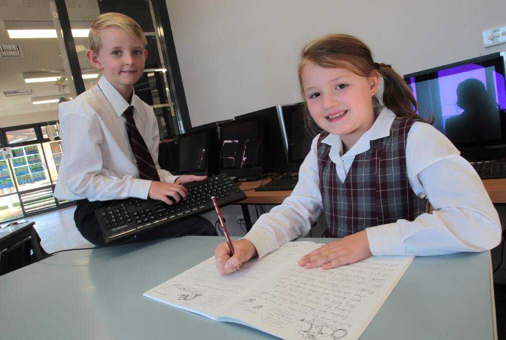 Wagga Christian College kids Sam Maclure, 9, and Carmen Fiala, 8, are taught both handwriting and keyboard skill at schools. Photo: Les Smith.