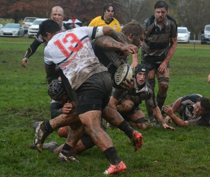 WET WEATHER FOOTY: Southern Inland's Farrel Moata tries to bring down a  Mid North Coast opponent in the Richardson Shield at Bowral.