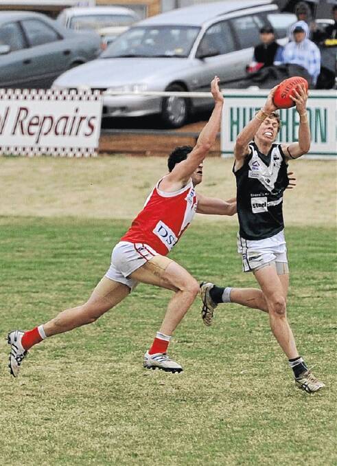 KEY INCLUSION: Coolamon young gun Joe Redfern takes a mark in front of Collingullie-Ashmont-Kapooka’s James Morris the last time the two teams met. Redfern will return to Coolamon’s team for today’s qualifying final against the Demons at Maher Oval. Picture: Michael Frogley