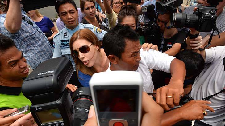 Rebuffed: Schapelle Corby 's sister Mercedes and husband Wayan fight their way through the media pack after visiting her before she was released. Photo: Justin McManus