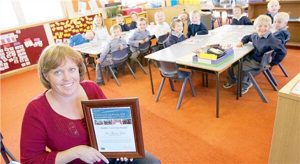 WELL-DESERVED ACCOLADE: Henty Public School kindergarten teacher Theresa Kane shows off her Quality Teaching Award she was presented last month by the Department of Education and Training to her class.