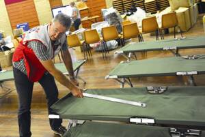 PACKING UP:  John Langley from A.C.E.R Disaster Recovery helps pack up the beds in the Wagga High School Hall.  	Picture: Addison Hamilton