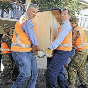 HEAVY LIFTING: Opposition Leader Tony Abbott (right) and member for Riverina Michael McCormack help North Wagga resident Ray Price carry some furniture out of his water-damaged house with the assistance of defence personnel. 	Picture: Oscar Colman