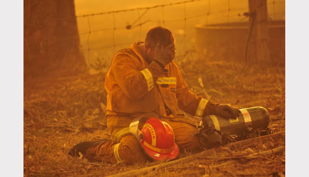 A firefighter rests as bushfires rage out of control from the Bunyip State Park towards the townships of Labortouche and Tonimbuk, Victoria in 2009. Photo: JASON SOUTH