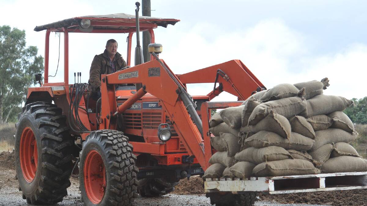 Mick Conway helps move sandbags on the tractor in Uranquinty. Picture: Oscar Colman