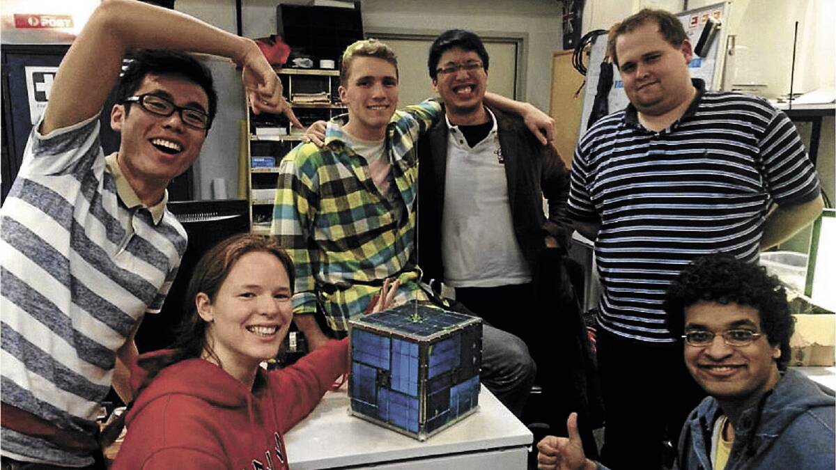 BOUND FOR SPACE: University of NSW engineering students (clockwise, from bottom left) Anne Gwynne-Robson, Chun-kan Leung, John Aiden Rohde, Thien Nguyen, Daniel Jedrychowski and Varun Nayyar show off the satellite which they hope will pass the test in Wagga next April to see it launched into space.