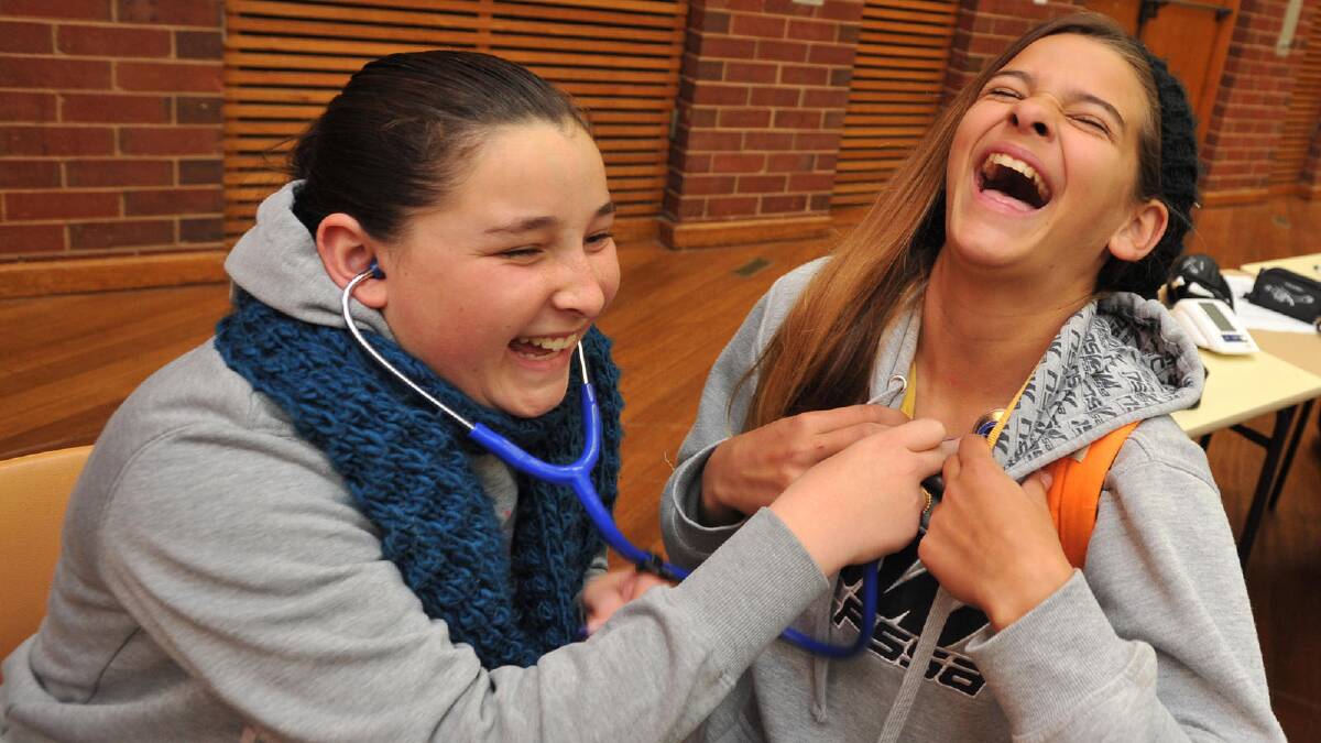 Mount Austin High School students Allira Timbery, 12, and Christina Grauer-Kompos, 13, have some fun at the Allied Health event (WARRIAHS) from CSU. Picture: Michael Frogley