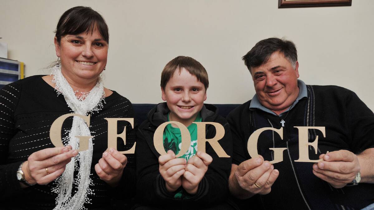 Kathy, George, 11, and Peter Pappas celebrate the naming of the new royal prince. Picture: Alastair Brook