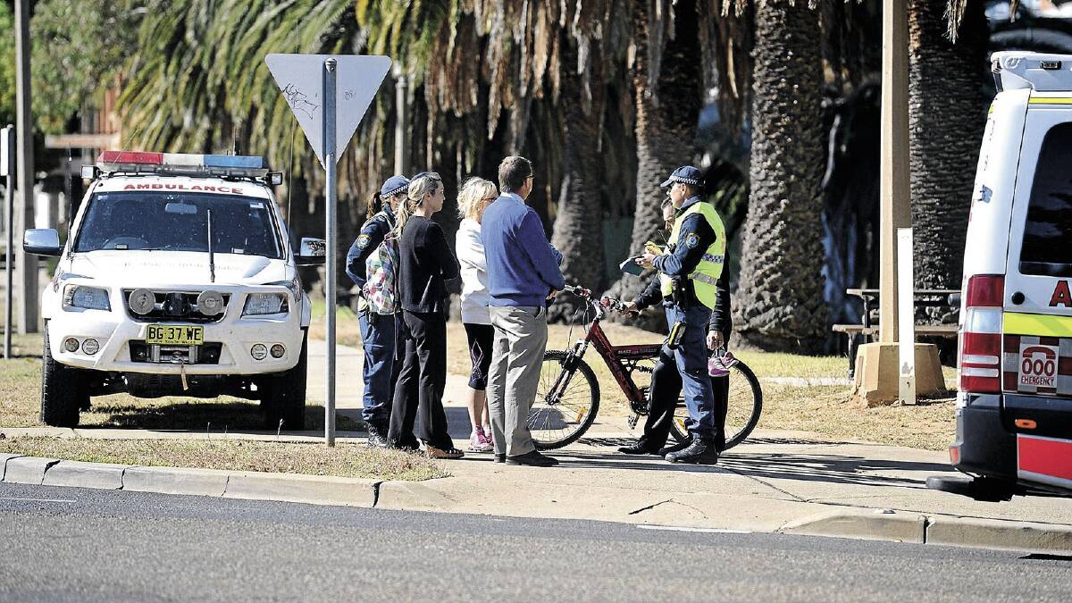 LUCKY ESCAPE: Emergency services personnel on the scene of an accident involving a car and cyclist Stephanie Brown at the corner of Trail and Johnston streets on Monday. Picture: Alastair Brook