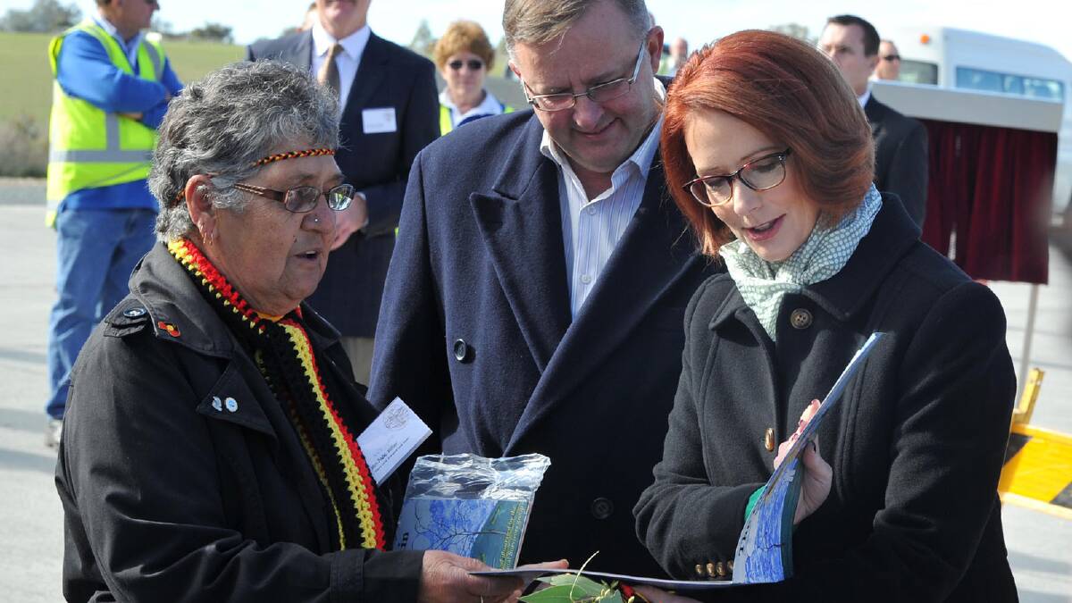 Aunty Avis Gale makes a presentation to Prime Minister Julia Gillard with Minister for Infrastructure and Transport Anthony Albanese looking on. Picture: Michael Frogley