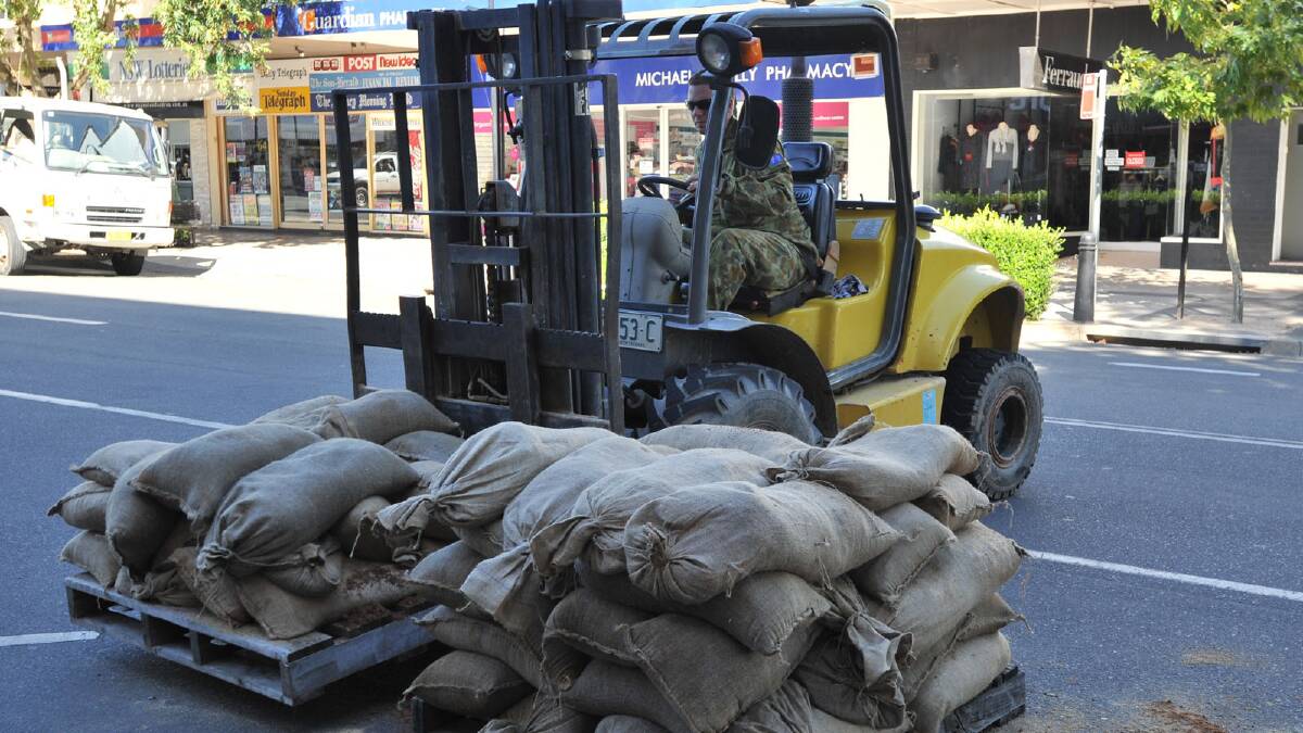 Sandbags are removed from shop fronts as residents are allowed back into the CBD. Picture: Michael Frogley
