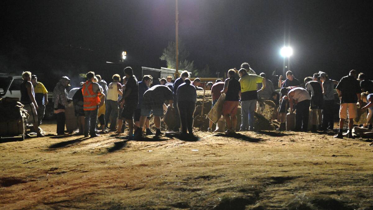 Volunteers and residents worked late into the night to fill sandbags to protect homes and businesses. Picture: Michael Frogley