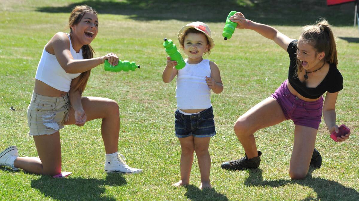 Headspace music festival for Youth Week. River Reid, 2, cools off courtesy of Madi Fisher, 15, and Lucy Musgrave, 15, all from Wagga. Picture: Les Smith