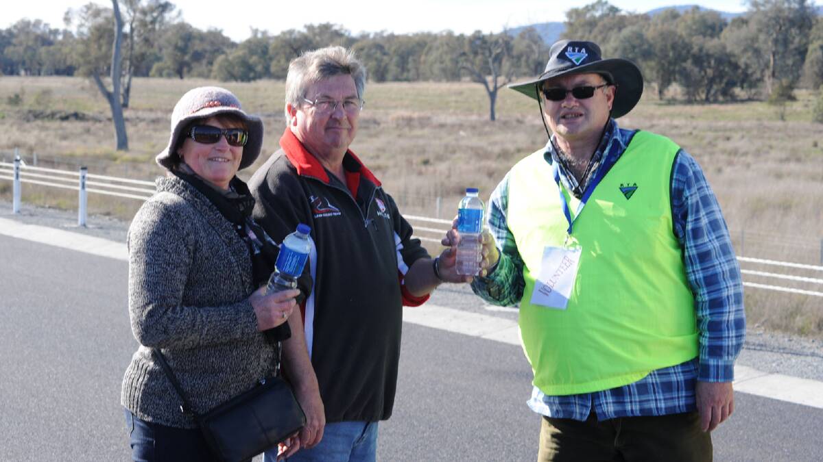 Judy and Russell Thopson from Wagga receiving the free water being offered by RMS employee, John Moroney. Picture: Keith Wheeler