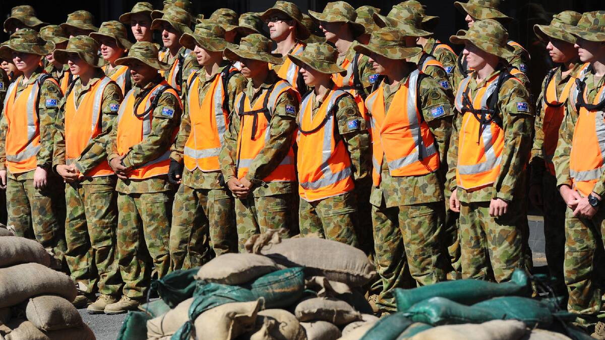 Kapooka Army soldiers assist to pack up sandbags from Fitzmaurice Street. Picture: Addison Hamilton