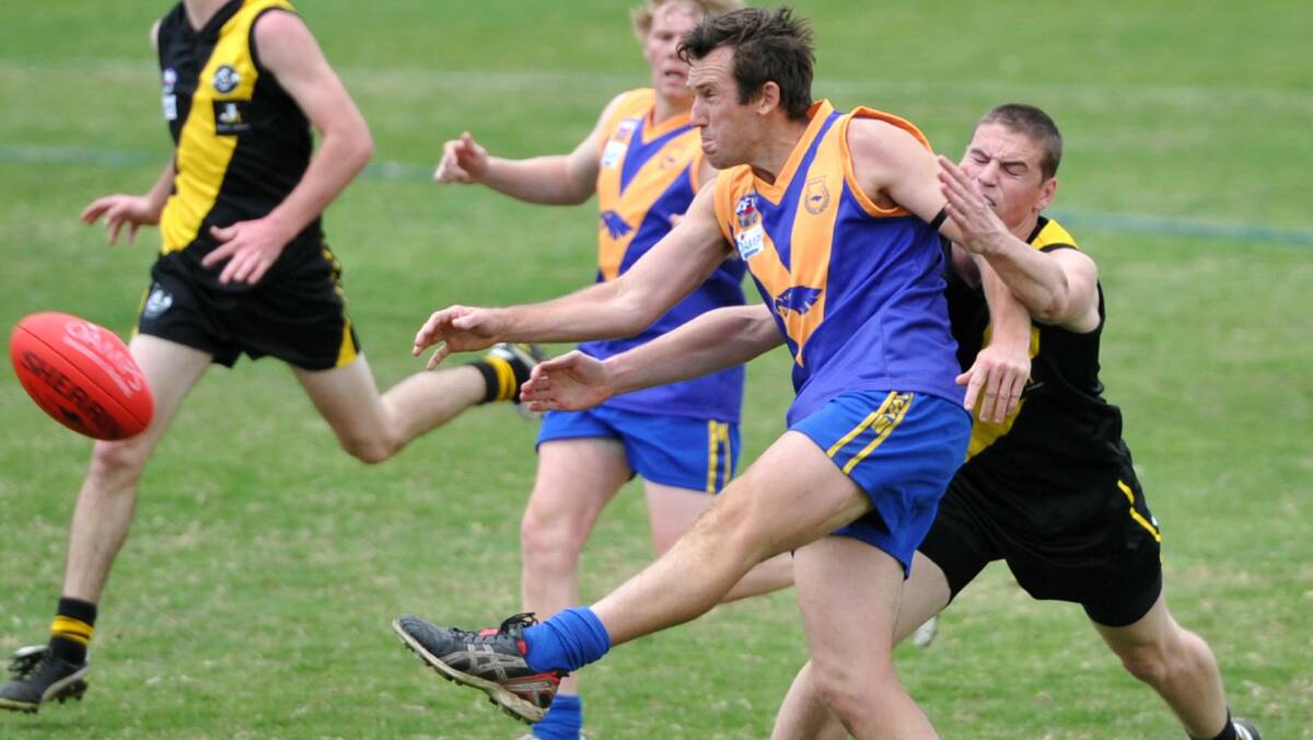 BACK IN BLUE: Jamie Grintell gets a kick away against Wagga Tigers in 2011. Grintell will return to Narrandera next season after two years coaching Northern Jets. Picture: Les Smith