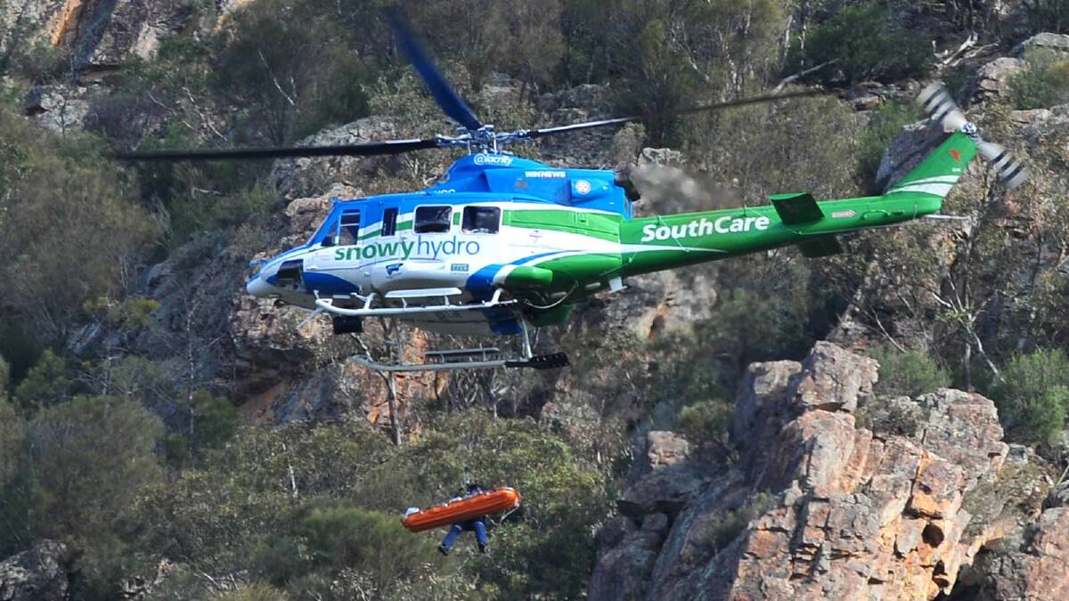 DRAMATIC RESCUE: A rock climber who plunged 15 metres from a cliff at The Rock was winched into a helicopter with the aid of a paramedic. 	Picture: Addison Hamilton