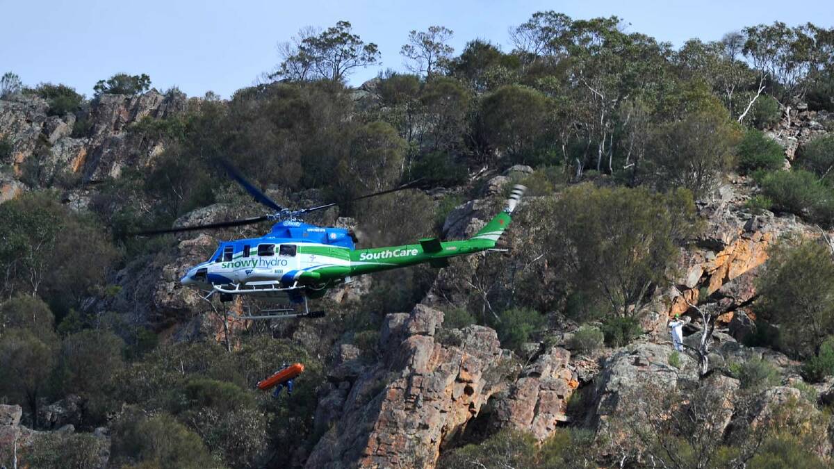 DRAMATIC RESCUE: A rock climber who plunged 15 metres from a cliff at The Rock was winched into a helicopter with the aid of a paramedic. 	Picture: Addison Hamilton