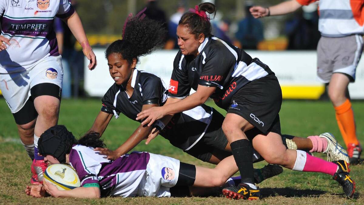 Leeton defeated Griffith 27-10 in the women's sevens. Leeton's Louise Wallace is tackled by Griffith's Niumai Serukabaivata and Desma Newman. Picture: Addison Hamilton