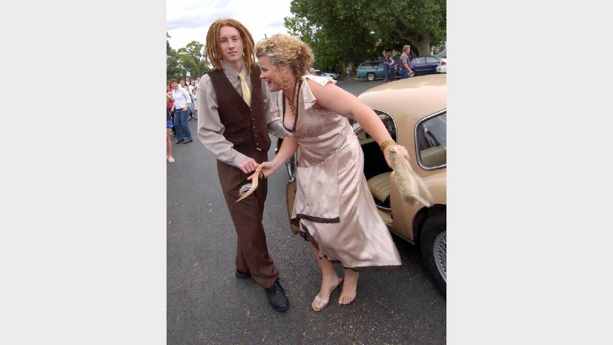 Jordan Thompson helps Sally Wood, who has thrown a shoe, at the Wagga High School Year 10 formal in 2004. Picture: Les Smith