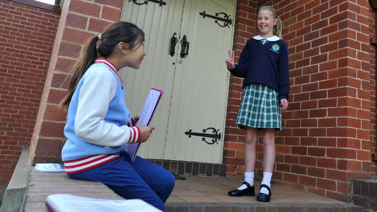 Lutheran Primary School students Stephanie Chan (9) and Zoe Jenkins (9) help each other with a last minute run through of their recital. Picture: Michael Frogley