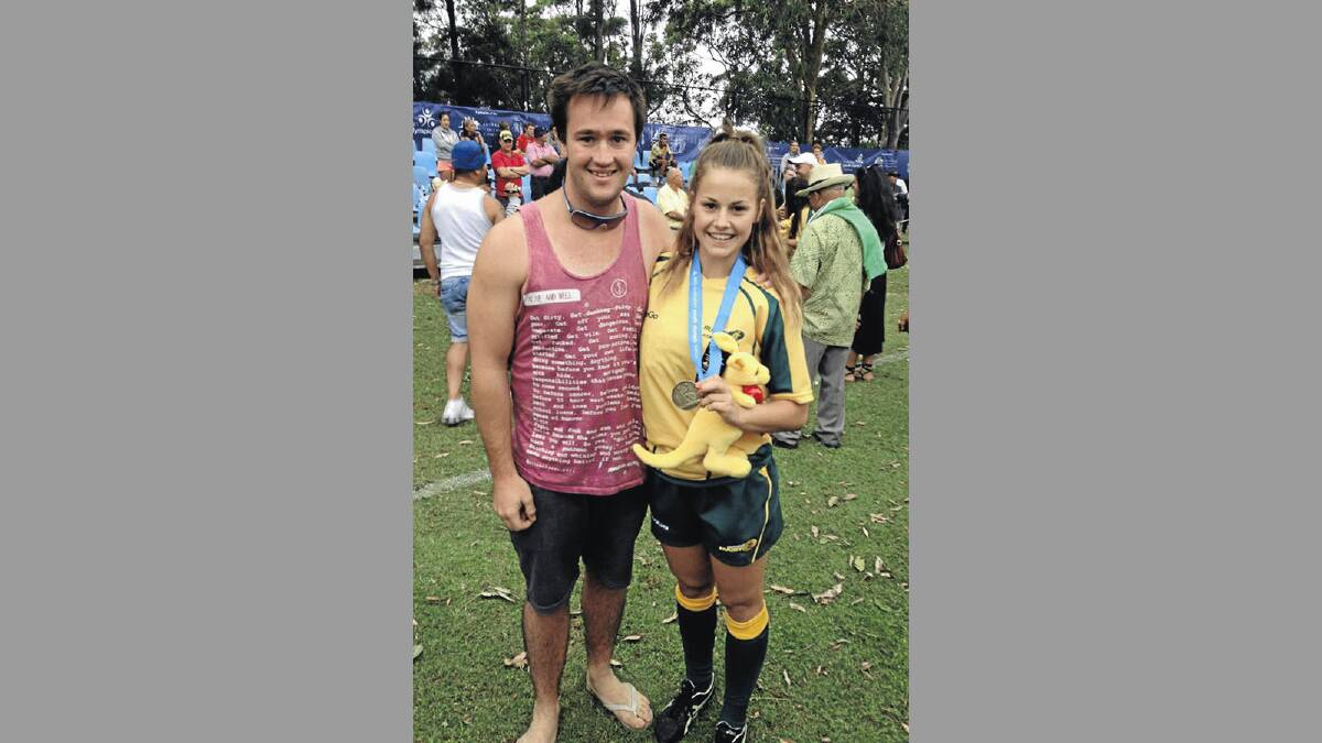 Wagga schoolgirl Rebeka Lally displays her gold medal and team mascot as she celebrates with cousin Dylan Rogers after the Rugby Sevens final at the Australian Youth Olympics Festival in Sydney on Saturday.