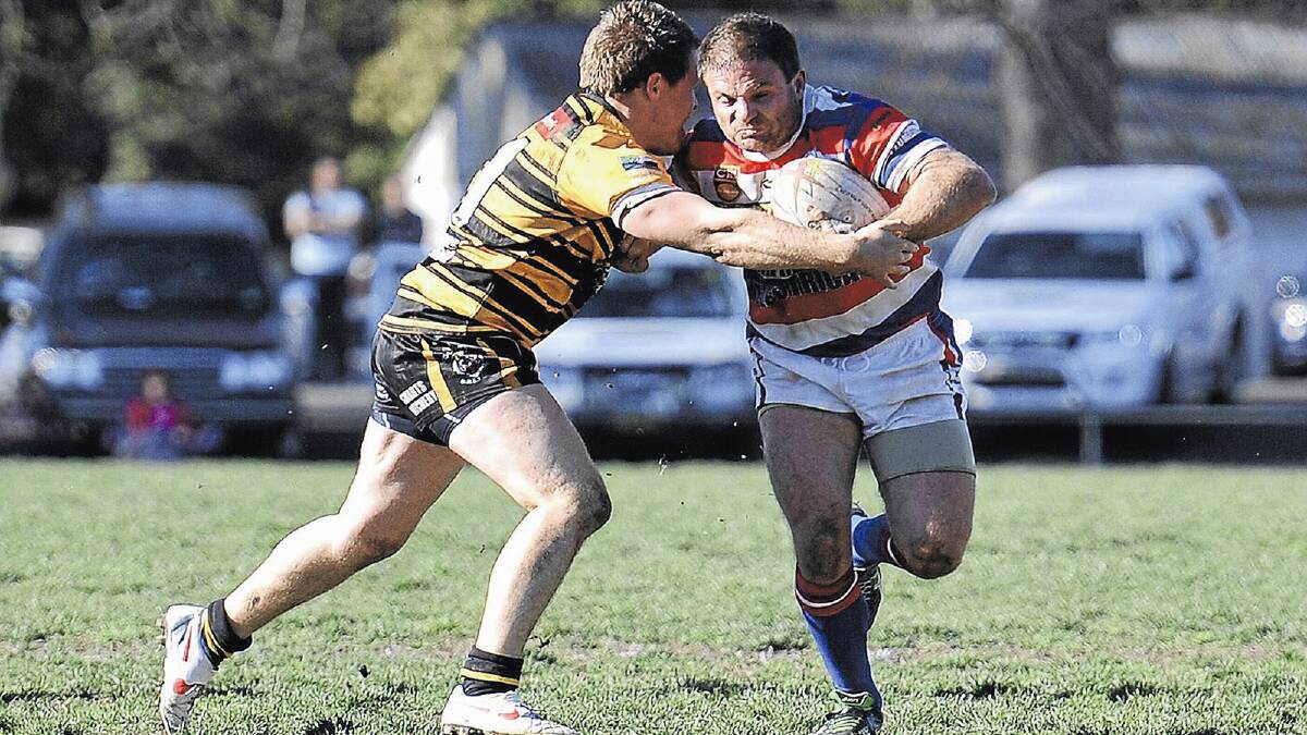 Ex-NRL star Simon Woolford (right) tackles Gundagai lock Cameron Woo last year. Woolford, who has retired, is among six critical losses for the Cherrypickers.