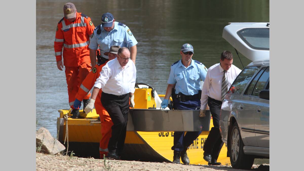 TRAGIC FIND: Police, SES volunteers and funeral home staff transfer the body of 19-year-old Chris Sahn from a rescue boat yesterday. Picture: Andrew Pearson