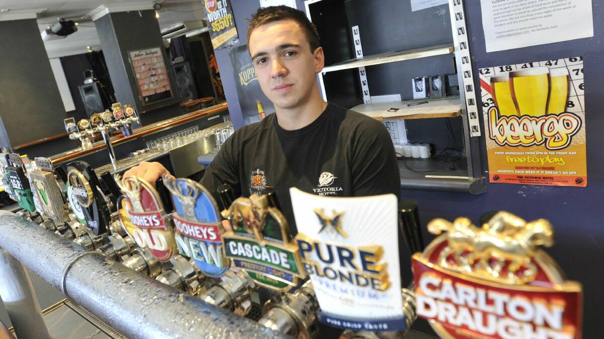 BAR TAB: Jacob Mintern behind the bar at the Victoria Hotel yesterday. While he understands why some employers are hit hard by penalty rates, he wouldn't be happy if any change saw his entitlements stripped. Picture: Les Smith