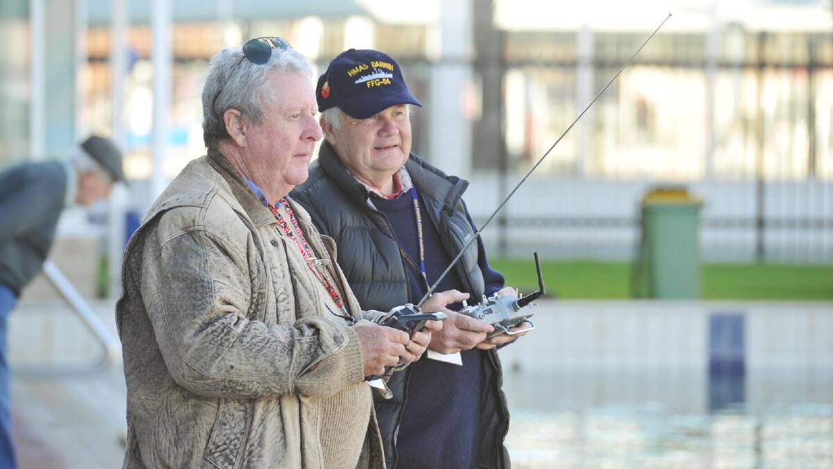 Richard Dawson, Newcastle, and Peter Cole, Canberra, pilot their ships on the water as part of the task force 72 scale model ship association at Oasis Swimming Centre. Picture: Alastair Brook