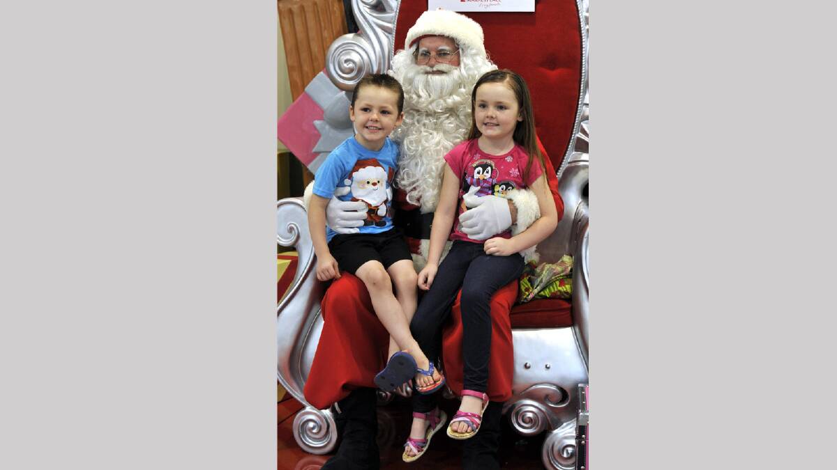 Jye, 4 and Zara Griston, 6, meet up with Santa at the Marketplace. Picture: Les Smith