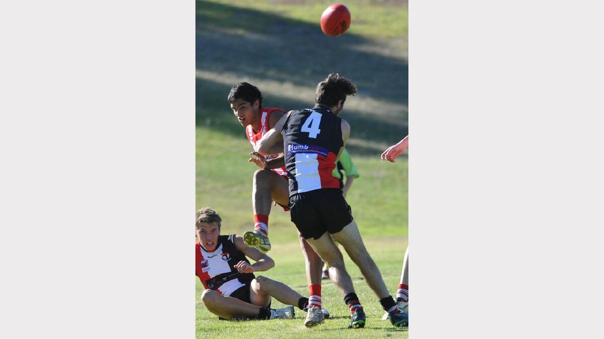 Ash de Clifford just gets a kick away for CSU under pressure from North Wagga's Jesse Margosis. Picture: Les Smith