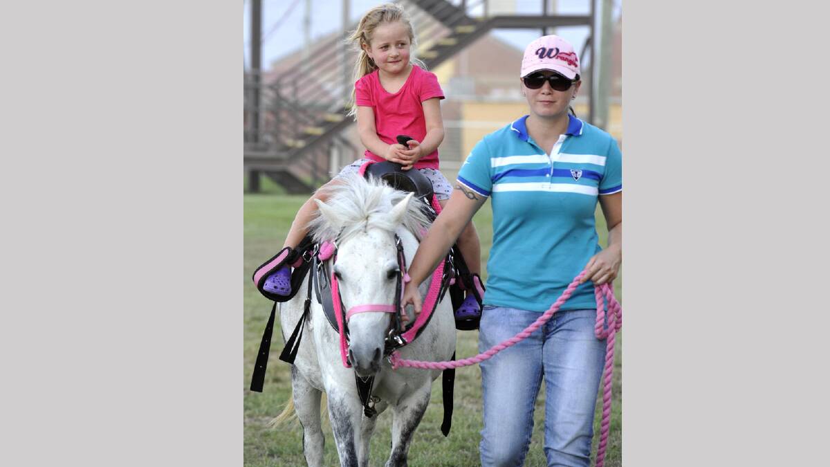 Four-year-old Haylee Neale has a ride on Girly at the Wagga trots with Lesley Thompson taking the reins,. Picture: Les Smith 