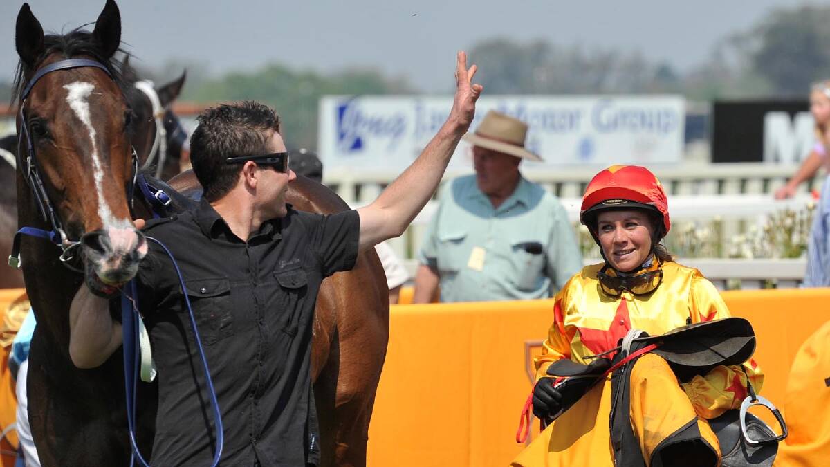 Trainer Brad Witt talks to jockey Megan Taylor after Black Canyon wins the second race of the Men of League Cup program. Picture: Michael Frogley