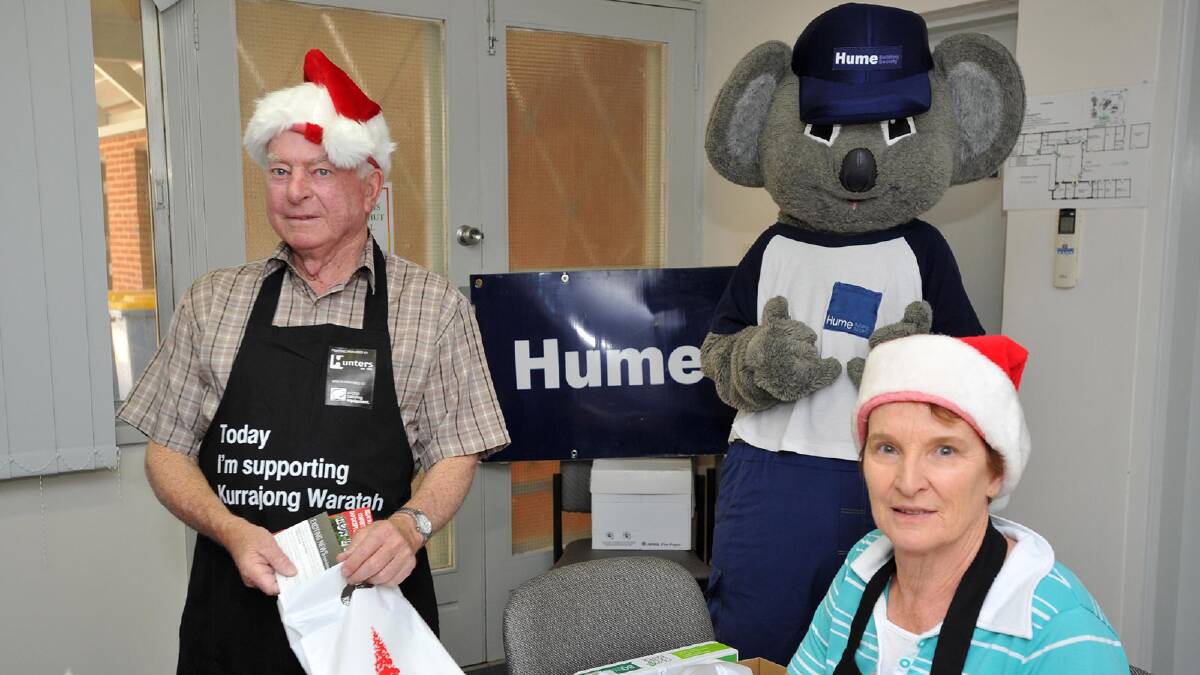 South Wagga Lyons Club volunteers Bill Carroll and Anne Leonard packing candle and bags for the Christmas Spectacular with Hume's Clancy the Koala. Picture: Michael Frogley 