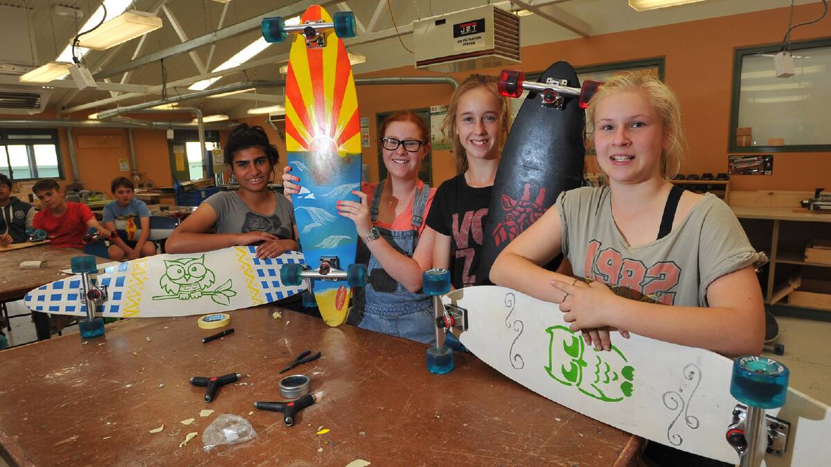 Thirteen-year-olds Duaa Fatima, Maddy Stoll, Annie Coles and Emma Dorsett display their longboards made as a school project at The Riverina Anglican College. Picture: Addison Hamilton