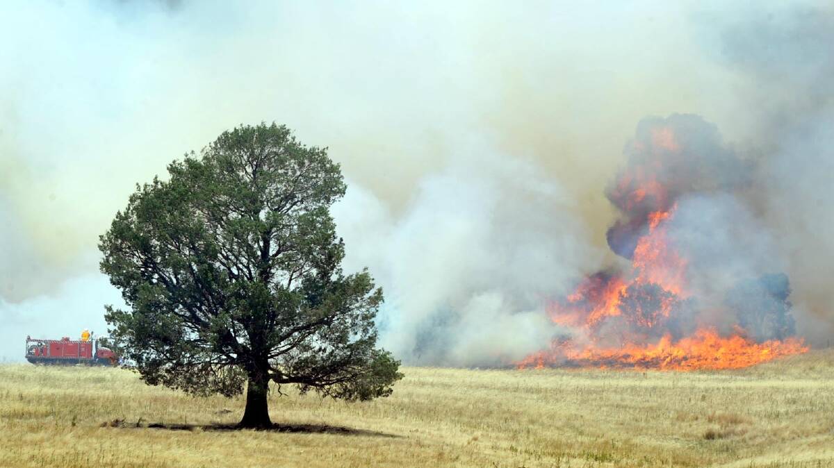 TOO CLOSE FOR COMFORT: Flames come dangerously close to the Oura township yesterday. Picture Les Smith