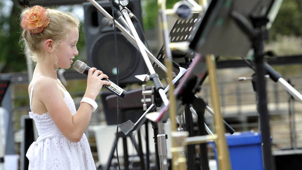 Amy Combes, 9, delivers a scripture reading during Wagga's 2013 Carols in the Amphitheatre. Picture: Les Smith