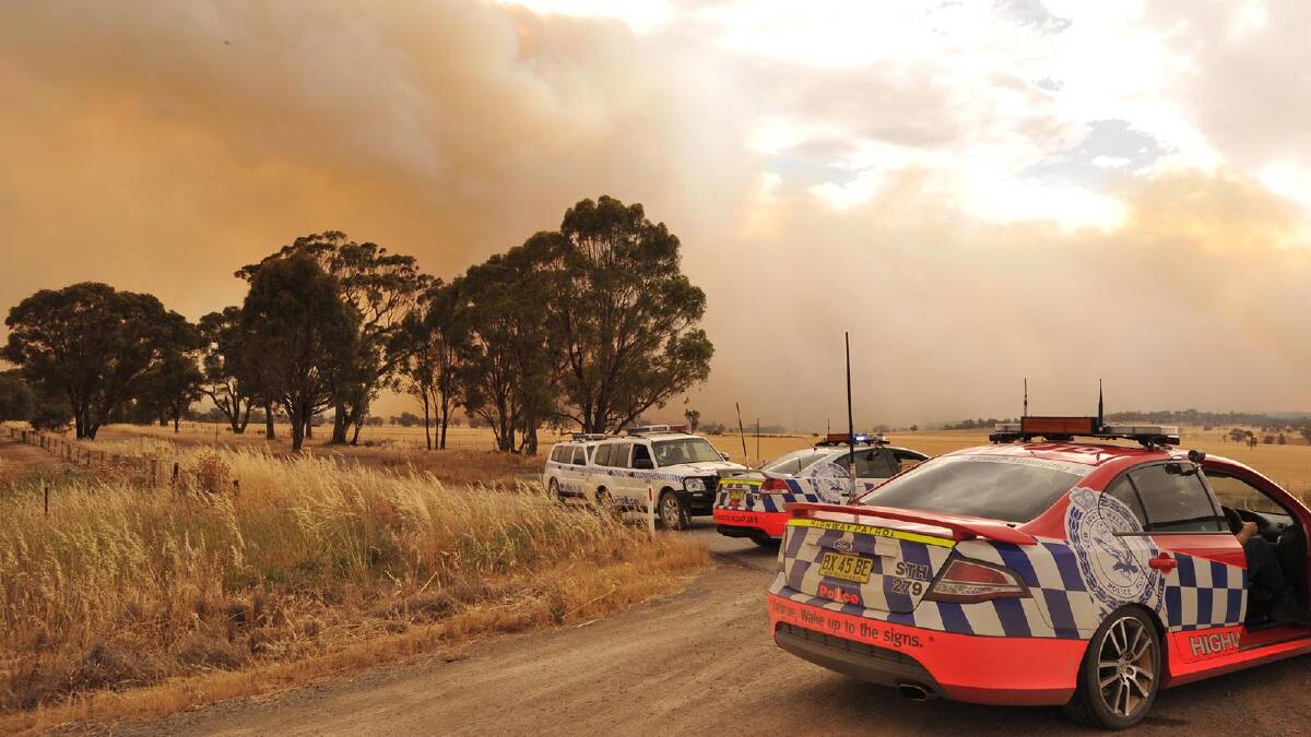Police blocking the roads as the blaze approaches the township of Stockinbingal. Picture: Michael Frogley
