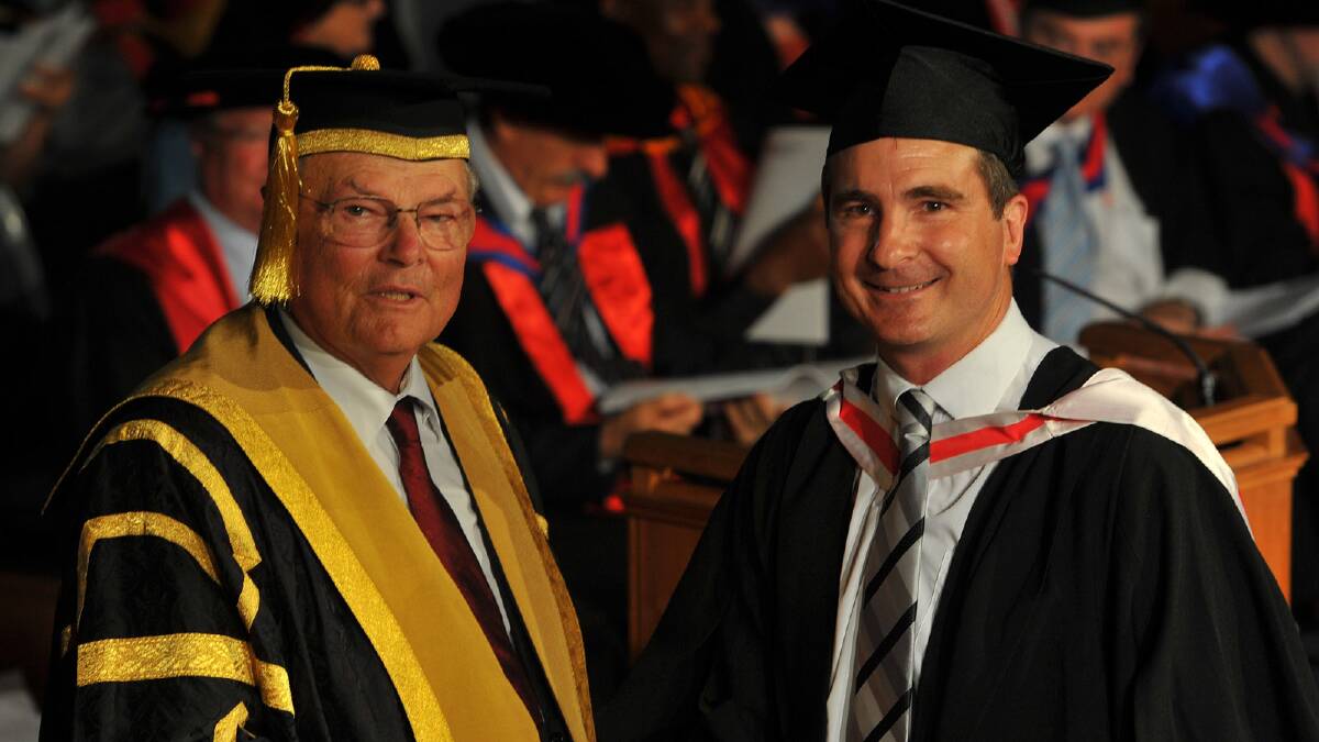 Michael McClintock receives his Bachelor of Arts (Television Production) from CSU chancellor Lawrence Willett. Picture: Addison Hamilton