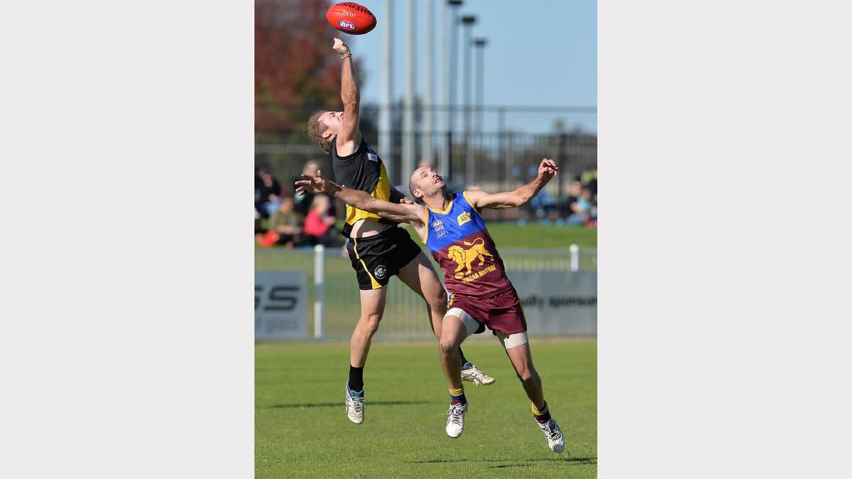 Patrick Noonan (left) thumps the ball away above Mitchell Steele. Picture: Michael Frogley