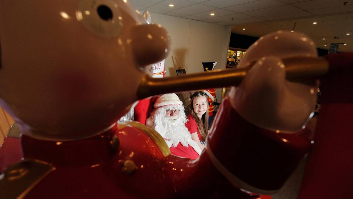  Santa's little helper Jasmine Dunn sits with Santa at the marketplace. Picture: Alastair Brook