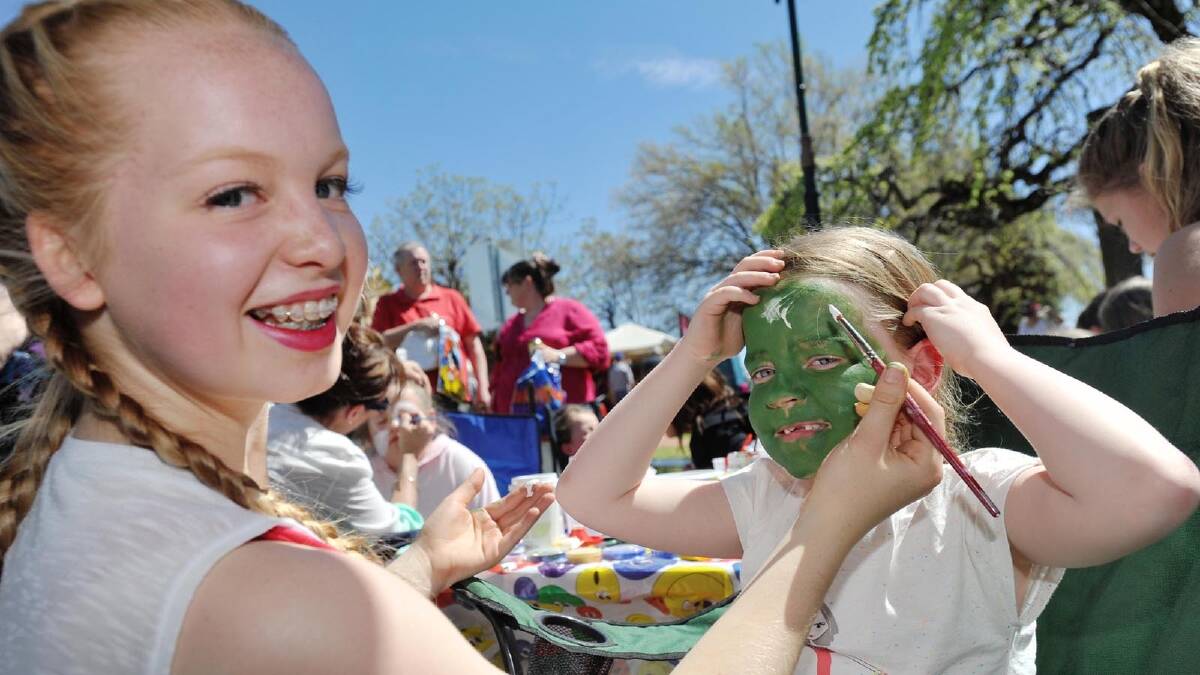 Holly Tinsley, 15, painting Charli Simcoe's, 6, face at the Coolamon Scarecrow Festival. Picture: Alastair Brook