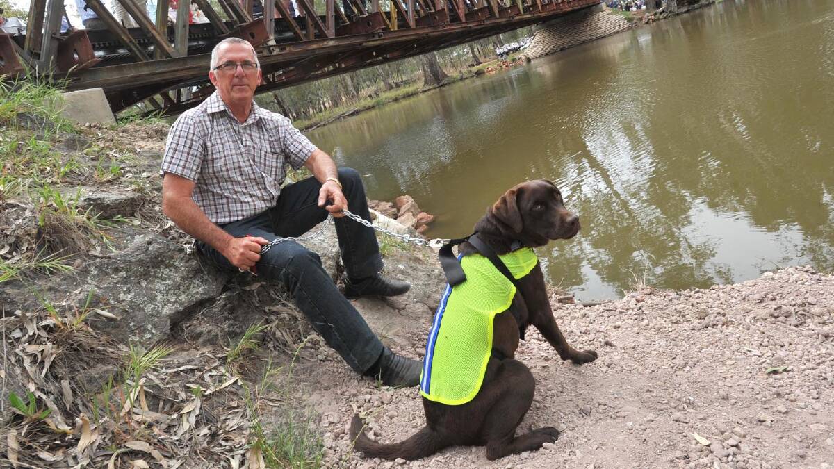 Ray Smith from Brisbane relaxes with his dog Tanza at the official opening of the Rocky Waterholes Bridge as part of Narrandera's sesquicentenary celebrations. Picture: Les Smith