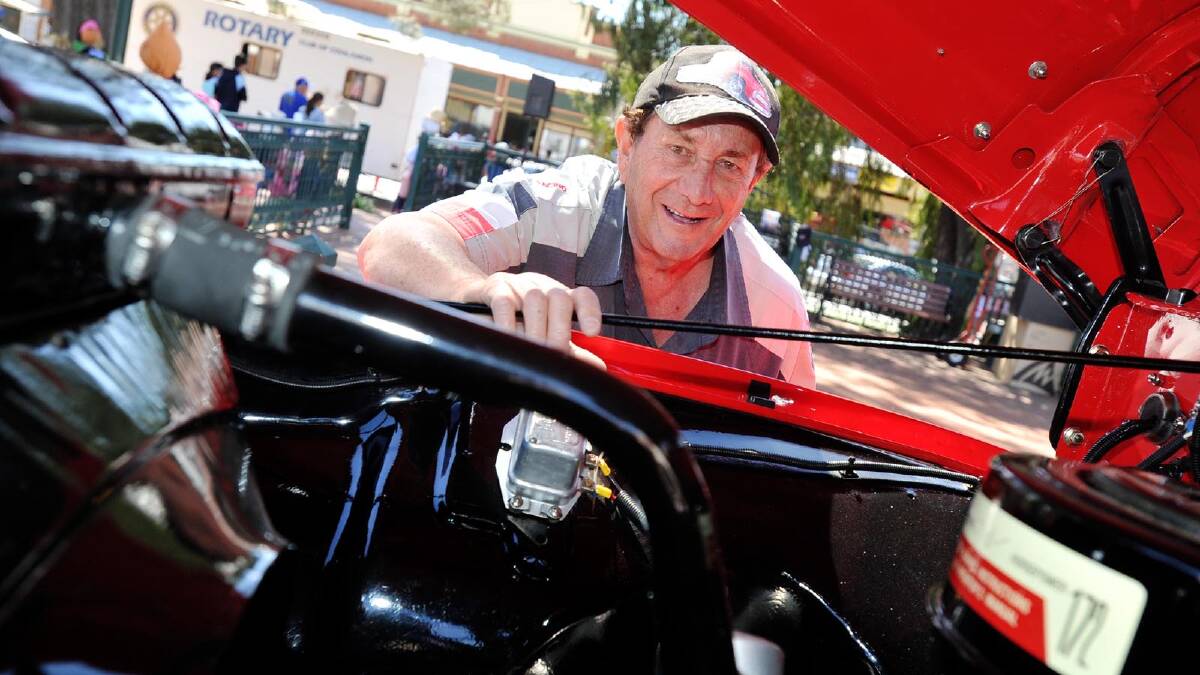 Des Gibbs looks in the engine bay of his immaculate restored '56 Ford F600 at the Coolamon Scarecrow Festival. Picture: Alastair Brook