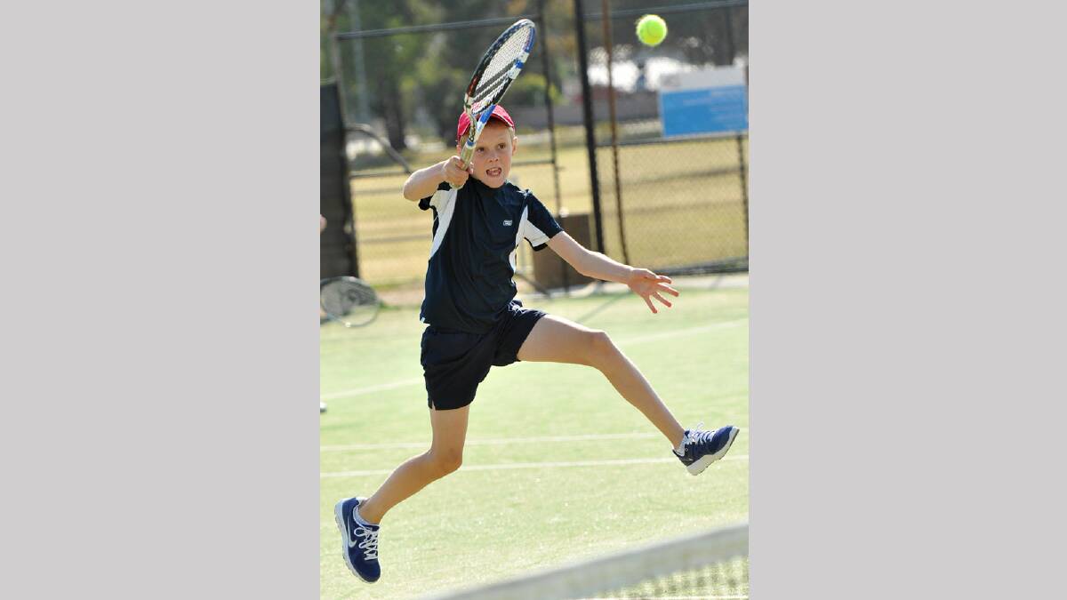 Hugh Kennedy, 11, attacks the ball close the net in junior tennis. Picture: Michael Frogley