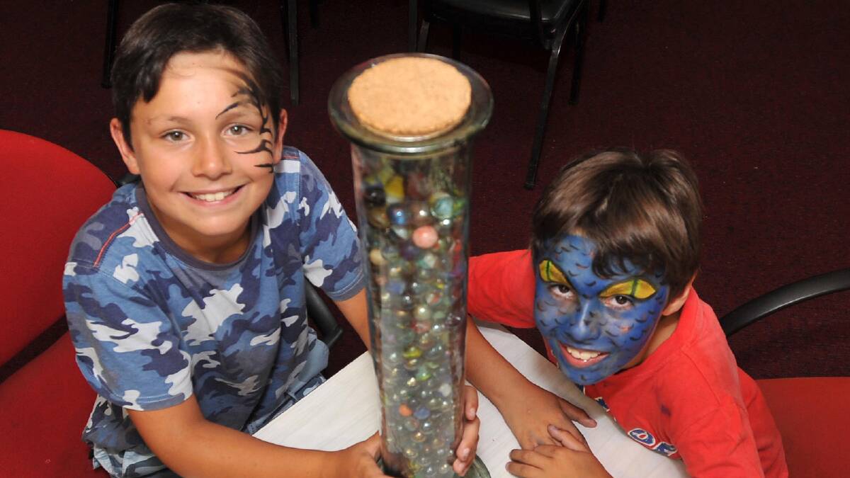 Nine-year-olds Brian Hare and Cain Dedini  look after the count the marbles competition at the Ganmain Bowling Club for a fund-raiser for Kellie Wall. Picture: Michael Frogley