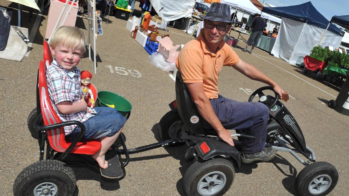 Four-year-old Oliver McCabe of Wagga with his dad Andrew handing out popcorn at the Sunday Markets. Picture: Les Smith
