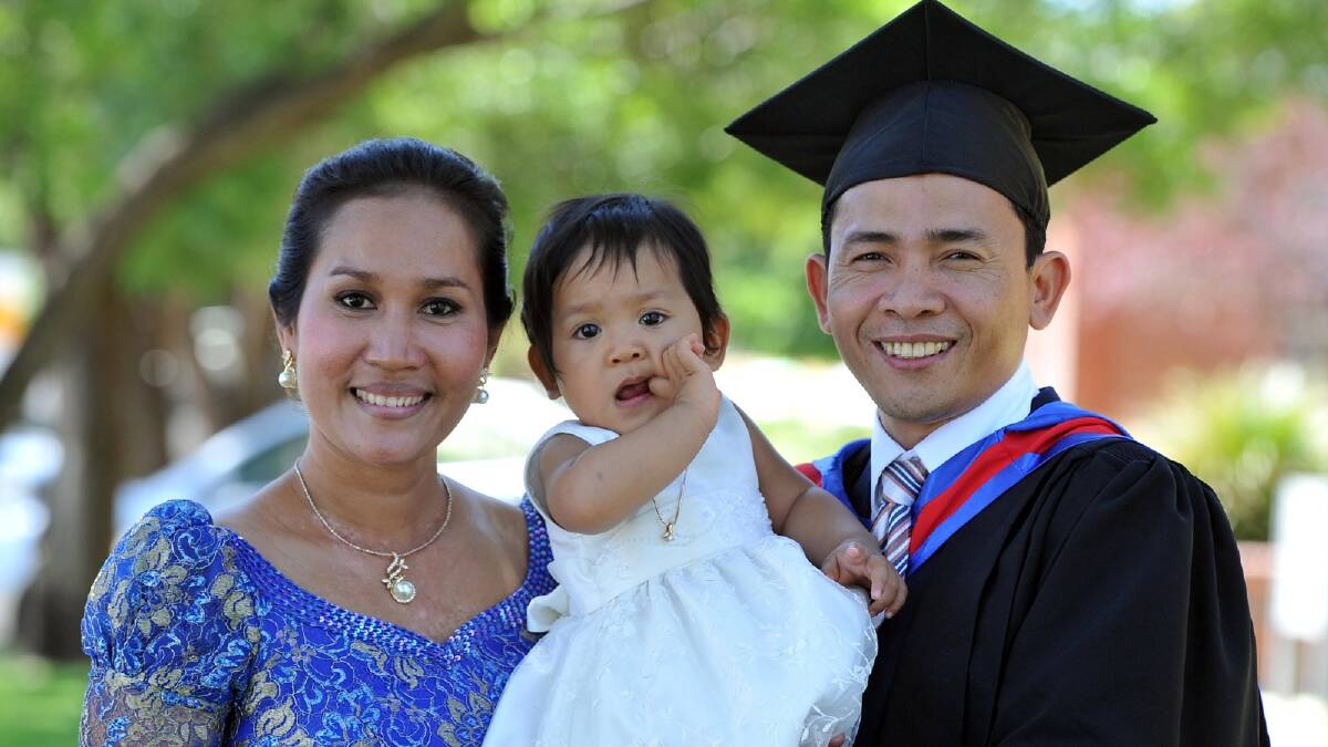 Kanal Doeur (right) is congratulated by wife Eang Erya and one-year-old daughter Doeur Sapor Ponita on receiving his Master of Business from CSU. Picture: Michael Frogley 